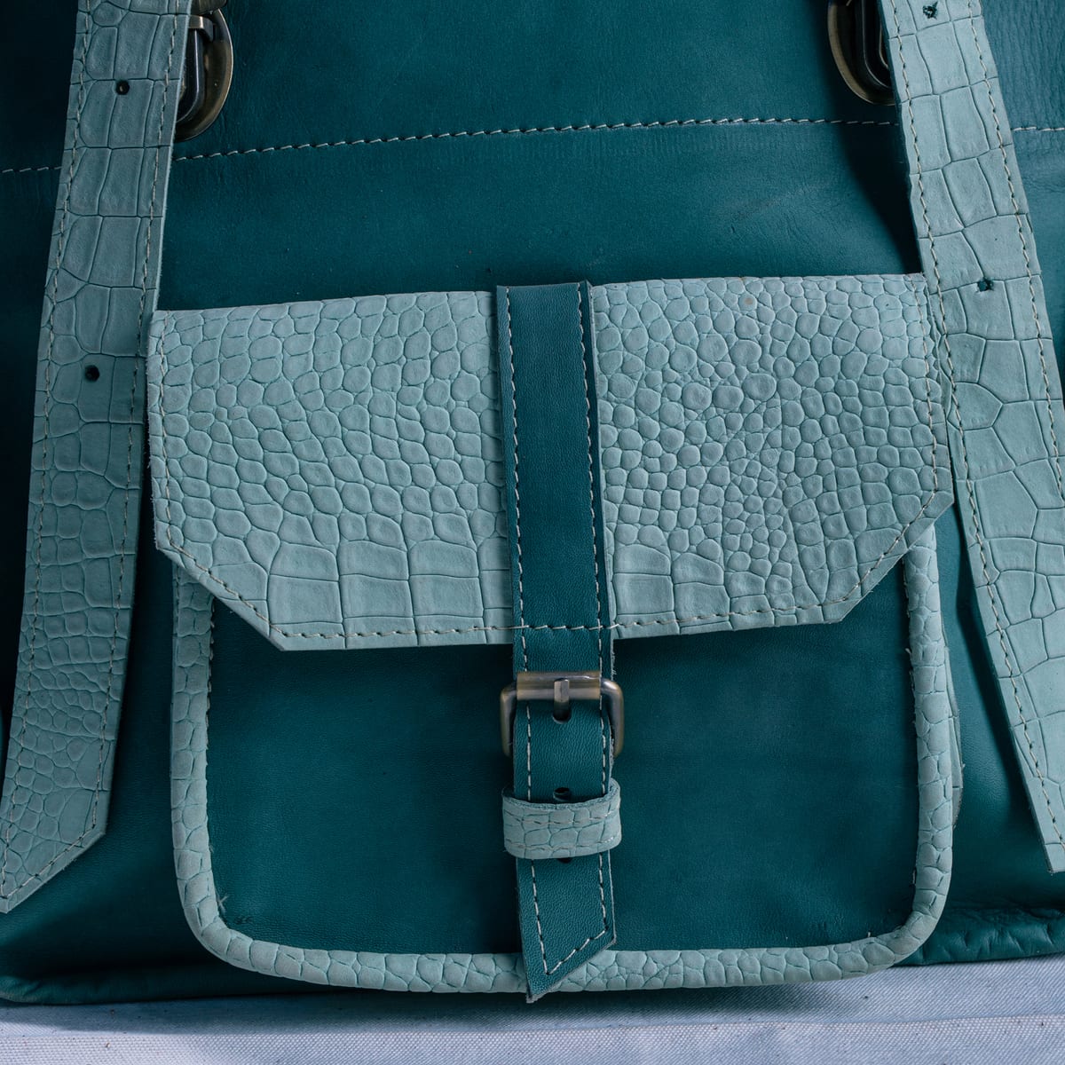 Close-up of a blue-green patina leather bag