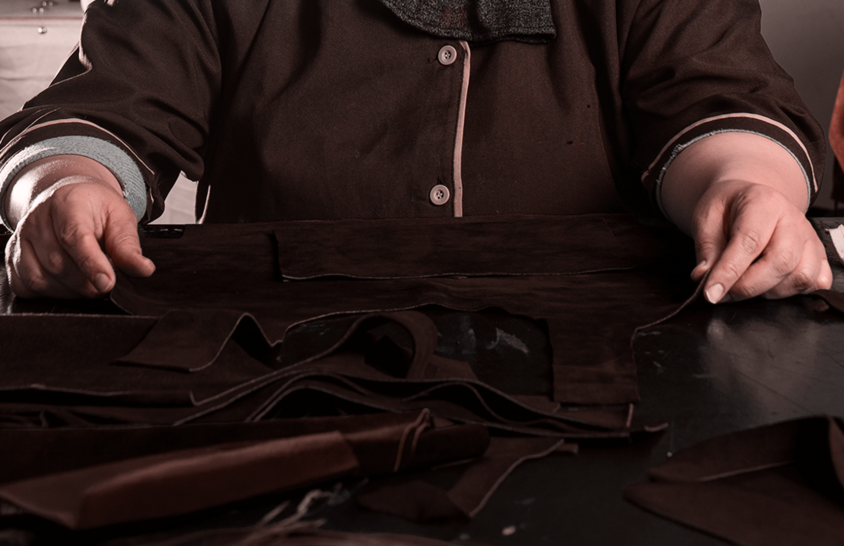 Artisan cutting dark leather by hand