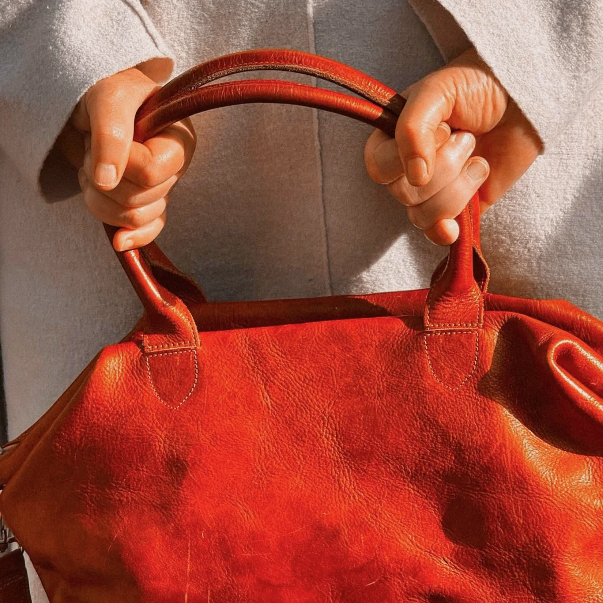 Customer holding the handles of a red Moroccan leather bag