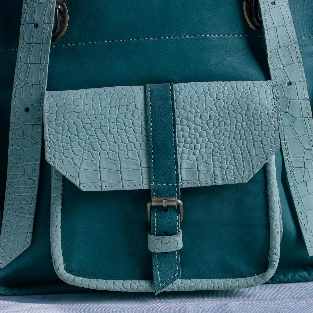 Gros plan sur un sac en cuir patiné bleu-vert