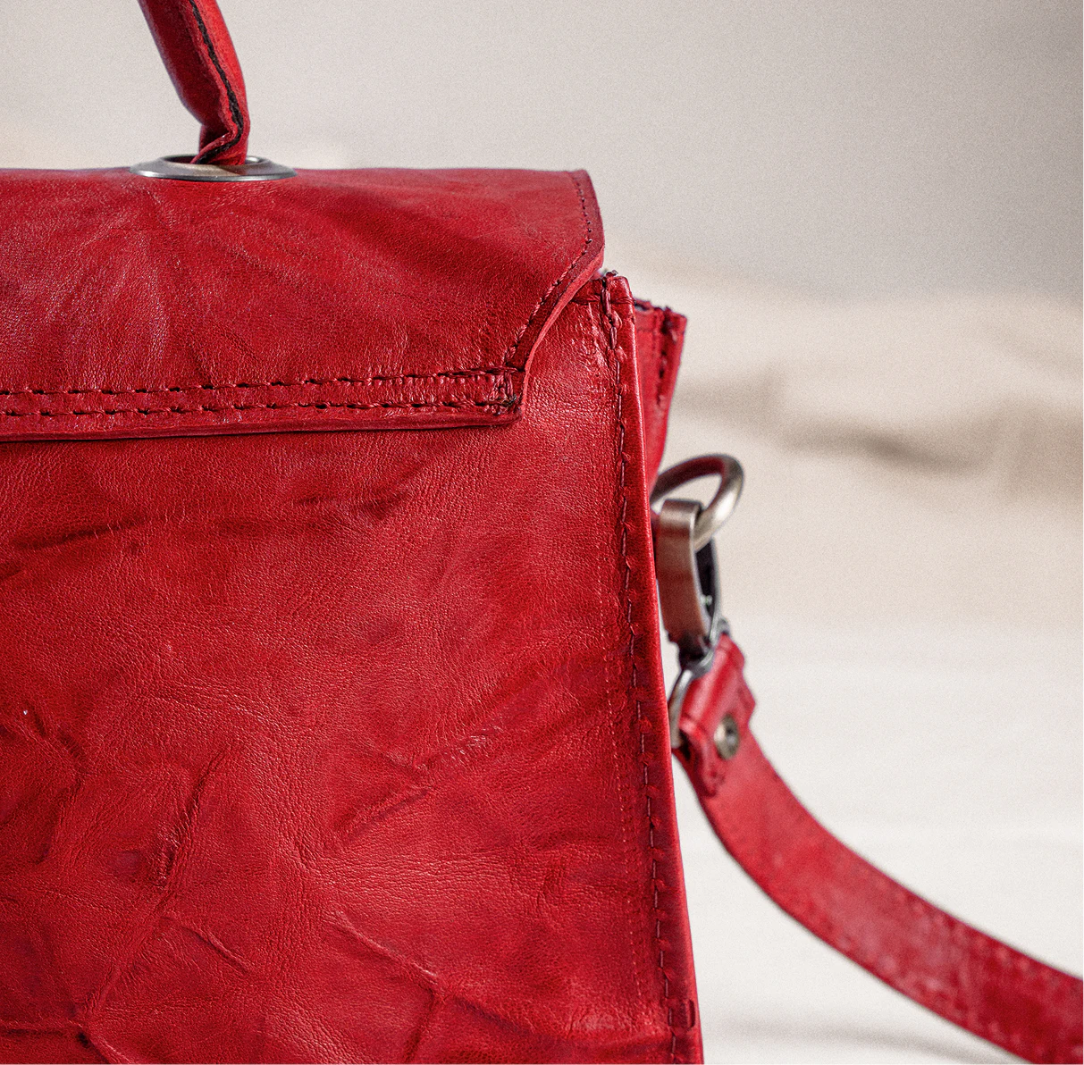 Gros plan sur le cuir pleine fleur rouge et ses coutures